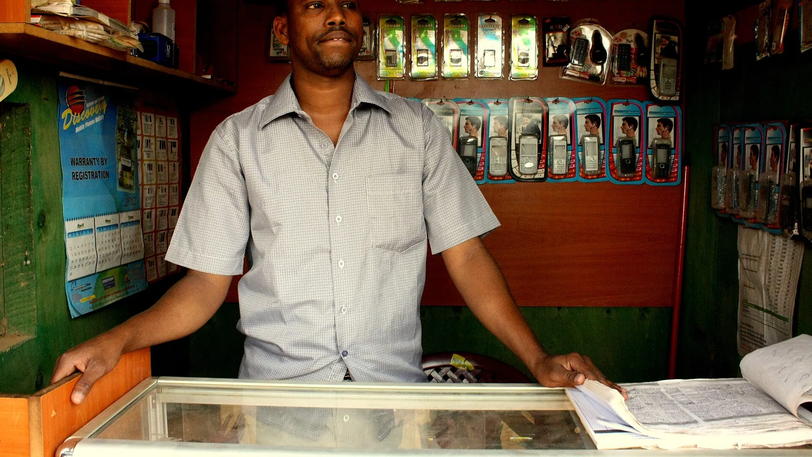 Shop owner showing saree catalogue on phone to customer